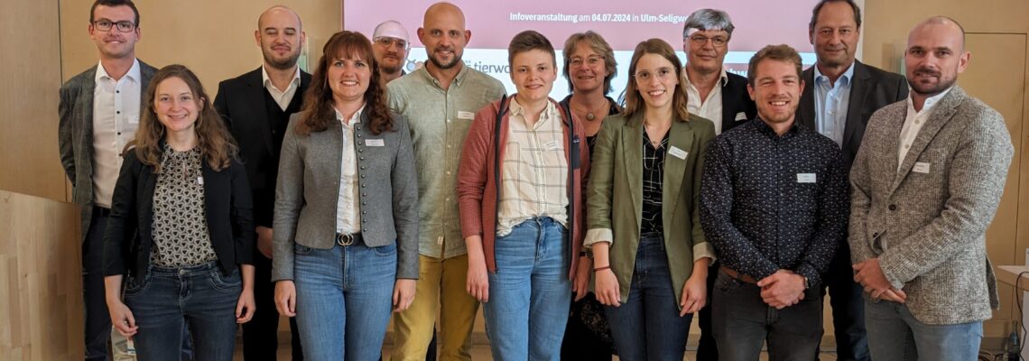 Gruppenfoto der Referent*innen der Veranstaltung vor einer Präsentationsleinwand.