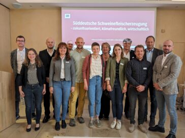 Gruppenfoto der Referent*innen der Veranstaltung vor einer Präsentationsleinwand.